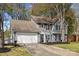 Charming two-story home with gray siding, blue shutters, mature trees, and a well-manicured front yard at 2439 Heathershire Ln, Matthews, NC 28105