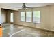 Living room with three large windows, ceiling fan, and a door to the backyard at 2752 Bramble Ridge Ct, Charlotte, NC 28215