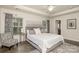 Spacious main bedroom with a tray ceiling, windows, curtains, and a stylish chair at 3009 Early Rise Ave, Indian Trail, NC 28079
