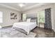 Bright main bedroom featuring dark wood flooring, a ceiling fan, large windows and patterned curtains at 3009 Early Rise Ave, Indian Trail, NC 28079