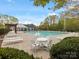 Community pool featuring lounge chairs, tables, chairs, a pool house and a clear blue sky at 3020 Salmon River Dr, Monroe, NC 28110