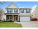 Charming two-story home with stone accents, a well-manicured lawn, and a two-car garage at 326 Nantucket Way, Rock Hill, SC 29732