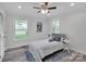 Bright bedroom with neutral walls, wood-look floors, ceiling fan, and large windows offering views of the green exterior at 3452 Flat Creek Rd, Lancaster, SC 29720