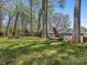 Enjoy this home's landscaped backyard with trees, firepit and deck at 3489 Lake Shore S Rd, Denver, NC 28037