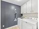 Well-organized laundry room with washer, dryer, storage cabinets, and grey accent wall at 3489 Lake Shore S Rd, Denver, NC 28037