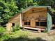 Charming wooden outbuilding with covered porch, perfect for a workshop or cabin retreat at 368 Northwood Dr, Troy, NC 27371
