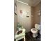 Powder room featuring beige walls, decorative wall hangings, a toilet, and vintage-style vanity and decorations at 368 Northwood Dr, Troy, NC 27371