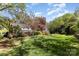 Expansive backyard with lush green lawn, mature trees, and charming landscaping details at 3916 Riverbend Rd, Charlotte, NC 28210