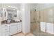 Bathroom featuring a glass enclosed shower, large mirror, granite countertop, and white cabinets at 3916 Riverbend Rd, Charlotte, NC 28210