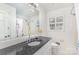 Clean bathroom showcasing a dark countertop with white cabinets and a large mirror at 3916 Riverbend Rd, Charlotte, NC 28210
