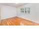 Simple bedroom with hardwood floors, white walls, a shuttered window and base trim at 3916 Riverbend Rd, Charlotte, NC 28210