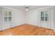 Bright bedroom featuring hardwood floors, two windows with shutters, and a classic ceiling fan at 3916 Riverbend Rd, Charlotte, NC 28210