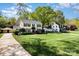 Expansive front lawn and well-maintained home exterior featuring lush landscaping and a detached garage at 3916 Riverbend Rd, Charlotte, NC 28210