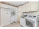 Functional laundry room with a white washer, dryer, cabinets, and a door to the outside at 3916 Riverbend Rd, Charlotte, NC 28210