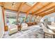 Cozy living room with wood ceiling beams, lots of natural light, a view of the landscaped yard, and comfortable seating at 3916 Riverbend Rd, Charlotte, NC 28210
