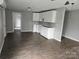 Open floor plan featuring a minimalist kitchen with white cabinets and hardwood flooring at 411 Weathers St, Shelby, NC 28150