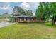 Charming brick ranch with mature tree in front yard, featuring a covered carport, shutters and manicured lawn at 417 Donna Ave, Gastonia, NC 28052