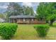 Charming brick home with covered carport, shutters, and manicured lawn surrounded by greenery at 417 Donna Ave, Gastonia, NC 28052
