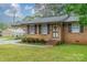 Close-up of a brick home entrance with dark shutters, wreath, and small front yard with lush green lawn at 417 Donna Ave, Gastonia, NC 28052