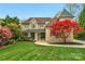 Attractive brick home featuring a turret, well-manicured lawn, and a vibrant red Japanese maple at 4300 Old Course Dr, Charlotte, NC 28277