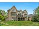 Expansive brick home with a covered porch and balcony overlooking a well-maintained lawn at 4300 Old Course Dr, Charlotte, NC 28277
