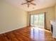 A bright bedroom featuring hardwood floors, ceiling fan, and sliding glass door to balcony at 535 Donatello Ave, Charlotte, NC 28205