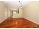 Open-concept dining room with hardwood floors, light fixtures, and neutral wall paint at 535 Donatello Ave, Charlotte, NC 28205