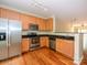 Well-lit kitchen boasts stainless steel appliances, wooden cabinetry and gleaming hardwood floors at 535 Donatello Ave, Charlotte, NC 28205