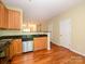 A well-lit kitchen provides stainless steel appliances, wooden cabinets and hardwood floors at 535 Donatello Ave, Charlotte, NC 28205