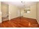 Spacious open-plan living room with hardwood floors leading to an adjacent dining area and stairs at 535 Donatello Ave, Charlotte, NC 28205