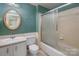 Bathroom with an oval mirror hanging above the sink, tile wall and a glass-enclosed shower at 6005 Fringe Tree Dr, Charlotte, NC 28227