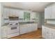 Bright kitchen features white appliances, laminate countertops, wood-look flooring, and natural light at 6005 Fringe Tree Dr, Charlotte, NC 28227