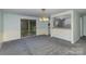 Open-concept living room and dining area with neutral carpet, slider doors to the backyard, and updated lighting at 6005 Fringe Tree Dr, Charlotte, NC 28227