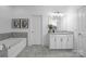 Bathroom with a tub, vanity, framed art, and stone countertops at 6020 Union Pacific Ave, Charlotte, NC 28210