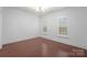 Empty bedroom showcasing gleaming hardwood floors, bright natural light, and window treatments at 6020 Union Pacific Ave, Charlotte, NC 28210