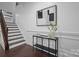 Elegant foyer with hardwood floors, staircase, wainscoting and stylish console table with decor at 6020 Union Pacific Ave, Charlotte, NC 28210