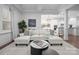 Spacious living room featuring stylish white sofa, hardwood floors, open layout, and seamless kitchen views at 6020 Union Pacific Ave, Charlotte, NC 28210