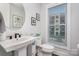 Bright bathroom featuring a modern sink, toilet, and window with natural light at 631 W Tremont Ave, Charlotte, NC 28203