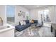 Bright living room features a plush blue sectional, round glass coffee table, and a sliding glass door at 631 W Tremont Ave, Charlotte, NC 28203