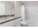 Bathroom featuring granite countertops, white cabinets and a shower/tub at 6619 Portland Rose Ln, Charlotte, NC 28210