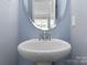 Modern powder room featuring a vessel sink and a round mirror at 6619 Portland Rose Ln, Charlotte, NC 28210