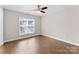 Bright bedroom with wood floors, ceiling fan, and a large window at 6619 Portland Rose Ln, Charlotte, NC 28210