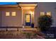 Inviting front entrance with stylish door, plants, and decorative lighting at 6619 Portland Rose Ln, Charlotte, NC 28210