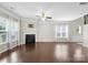 Open living room featuring dark laminate flooring, a fireplace, and large windows at 6619 Portland Rose Ln, Charlotte, NC 28210