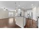 An open-concept living area with laminate flooring, a breakfast bar, and a view into the kitchen at 6619 Portland Rose Ln, Charlotte, NC 28210