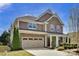 Charming two-story home showcasing a stone facade, complemented by a well-manicured lawn and neutral color palette at 704 Fresia Dr, Tega Cay, SC 29708