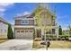 Charming two-story home showcasing a stone facade, complemented by a well-manicured lawn and neutral color palette at 704 Fresia Dr, Tega Cay, SC 29708