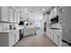Bright kitchen featuring white cabinetry, modern appliances, and seamless flow into the dining and living areas at 704 Fresia Dr, Tega Cay, SC 29708