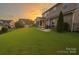 Expansive backyard with lush green grass, mature trees, and a cozy screened porch perfect for relaxation and outdoor enjoyment at 704 Fresia Dr, Tega Cay, SC 29708