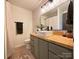 Bathroom featuring wood counters, decorative wallpaper, gray cabinetry, modern sink and black matte hardware at 715 21St Ne Ave, Hickory, NC 28601